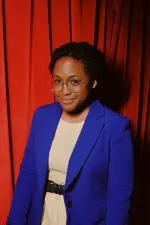 Kenice Mobley smiling confidently during a live comedy performance