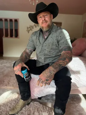 Jason Ellis, known as Wolfmate, posing confidently with tattoos and skateboard-inspired energy