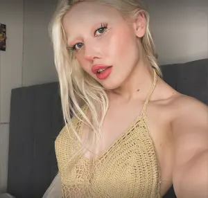 Naomi Woods posing in a chic, minimalist setting, reflecting her confident and fashion-forward style.