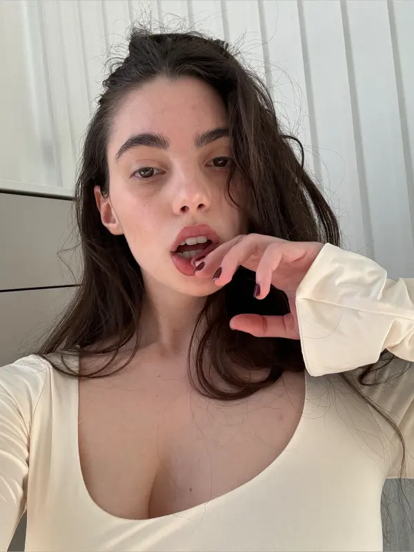 Curly🍒, also known as xoxocurly.tv, posing in a stylish outfit while filming lifestyle content.